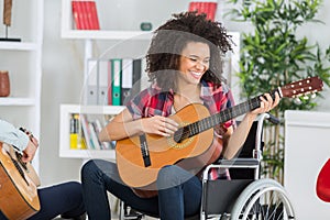 disabled young woman playing guitar at home