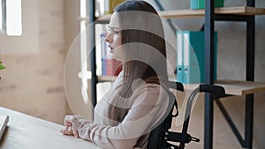 Disabled young woman talking to collegue at office