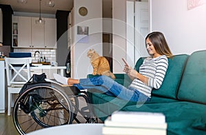 Disabled young woman using smartphone at home