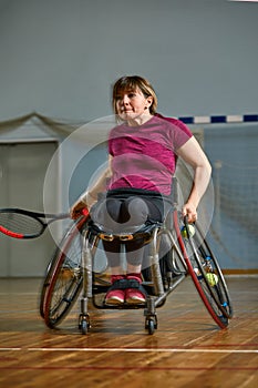 Disabled young woman on wheelchair playing tennis on tennis court