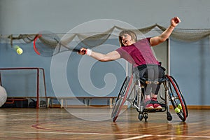 Disabled young woman on wheelchair playing tennis on tennis court