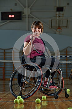 Disabled young woman on wheelchair playing tennis on tennis court