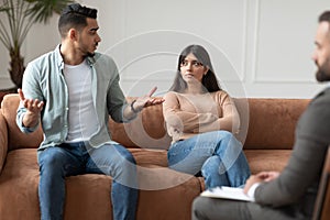 Couple talking at therapy session with male therapist