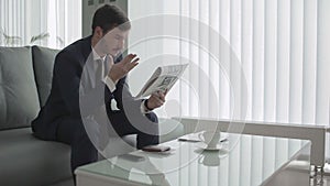 Disapointed businessman waits the boarding on the plane in a vip lounge hall