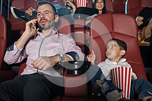 Disappointed boy in the movies with dad