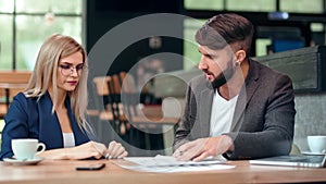 Disappointed businessman gesticulating scolding angrily talking with woman pointing mistake document