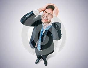 Disappointed businessman holds his head. View from top