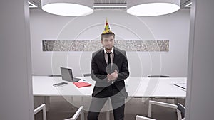 Disappointed Caucasian man in suit sitting in office alone at Birthday clapping talking with dissatisfied facial