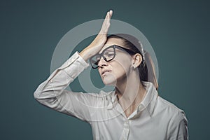 Disappointed confused woman doing a facepalm gesture