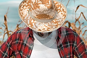 Disappointed corn farmer with his head down in cornfield