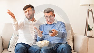 Disappointed Elderly Father And Son Watching Match At Home, Panorama