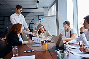 Disappointed leader of business team sit full of sadness on table with co-workers