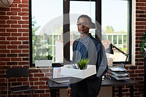Disappointed looking african american employee being fired leaving office