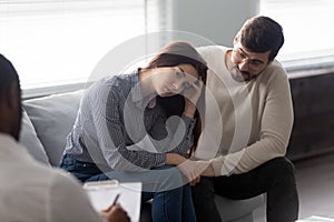 Disappointed man and woman at reception with family therapist.