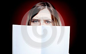 Disappointed and sad young girl holding exercise book