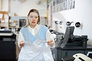 Disappointed woman with crumpled paper in publishing facility
