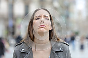 Disappointed woman looking at camera on street