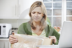 Disappointed Woman Unpacking Online Purchase At Home