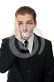 Disappointed young businessman with pacifier