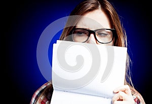 Disappointed young girl with nerd glasses holding