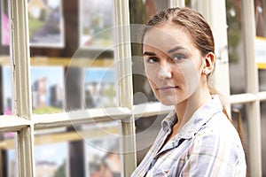 Disappointed Young Woman Looking In Window Of Estate Agents photo