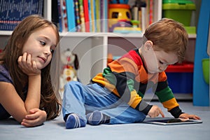 Disappointing girl with her little brother using a digital table