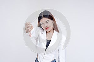 A disapproving young woman showing a thumbs down while staring at the camera. Isolated on a white background