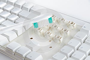 Disassemble and clean up a dirty white keyboard with a toothbrush.