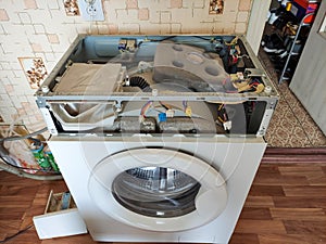 Disassembled broken washing machine in the kitchen