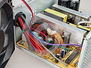 Disassembled computer power supply for repair, internal device of the PSU, capacitors, voltage stabilizer, frequency filter, effic photo