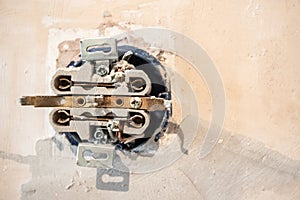 Disassembled electrical outlet in detonation wall with bare wires and hallmarks during repair in apartment