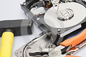 The disassembled hard drive next to the tools with which it was disassembled