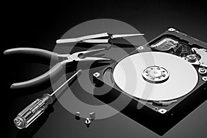 Disassembled hard drive and tools are on the operating table