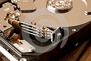 Disassembled hard drive on wooden table . Close up