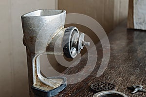 Disassembled manual vintage meat grinder on  wooden table