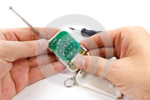 Disassembled security system remote control in man`s hand