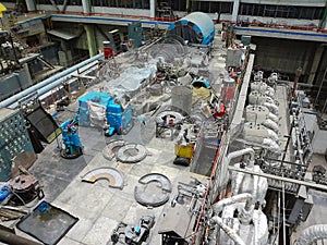 Disassembled steam turbine in the process of repairing and electric generator at power plant