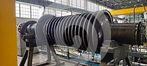 Disassembled steam turbine in the process of repairing and electric generator at power plant