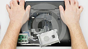 Disassembling a laptop. Master removes the battery from the laptop. A repairman removes a Li-ion electric battery