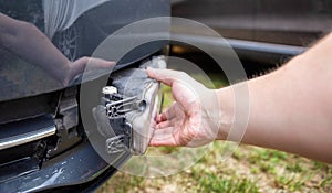 Disassembling and removing the fog lamp from a car to replace a burnt out light bulb. Close-up