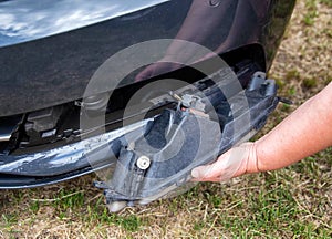Disassembling and removing the fog lamp from a car to replace a burnt out light bulb. Close-up