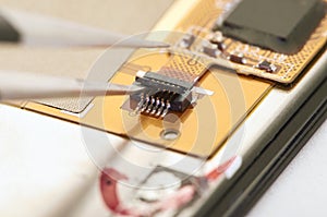 Disassembly of smartphone showing electrical board inside. The p