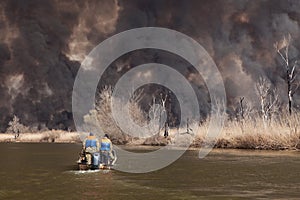 Disaster. Large fire on banks of Volga River in Astrakhan region. Russia. Black dense smoke and ash from burning reeds rises high