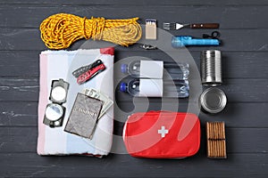 Disaster supply kit for earthquake on black wooden table, flat lay