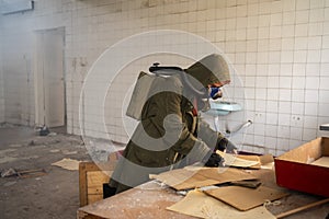 Disaster survivor in a post apocalyptic setting, she is wearing a gas mask and reading document. Environmental pollution