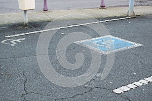 disbaled parking only sign, white on asphalt and blue with white frame in the middle e parking space