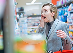 Disbelief. Surprised woman in supermarket
