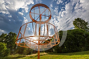 Disc golf basket in summer park