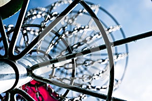 Underneath a disc golf goal looking up with selective focus on the chain basket.