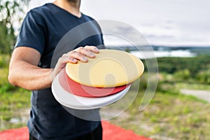 Disc golf player with frisbee equipment in park course. Man playing discgolf. Outdoor sport tournament. Summer landscape.